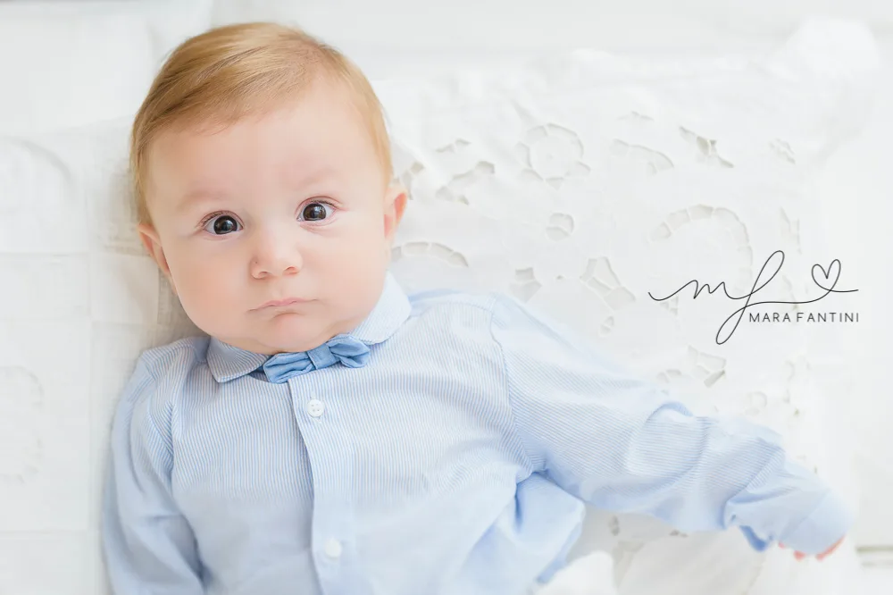 Battesimo Roma – ritratto del bebè Servizio fotografico battesimo Roma: primo piano del bambino in abito bianco da cerimonia