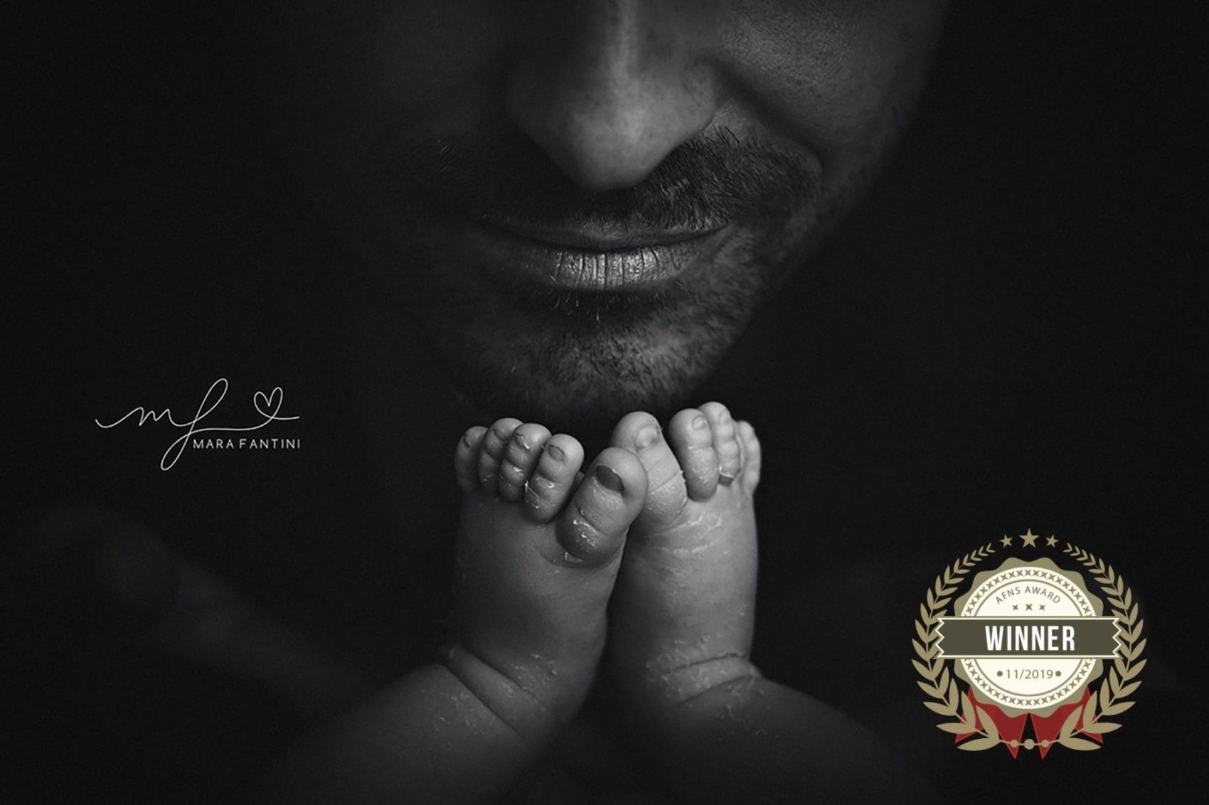 Foto neonato piedini papà - scatto vincitore premio | Mara Fantini Roma Piedini del neonato vicino al viso del papà, foto vincitrice di un premio internazionale di fotografia