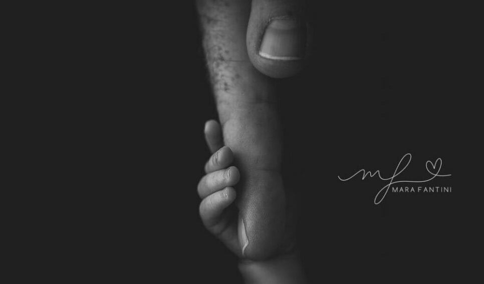 Foto neonato bianco e nero mano papà | Mara Fantini Roma Manina del neonato stretta nella mano del papà, foto in bianco e nero in studio