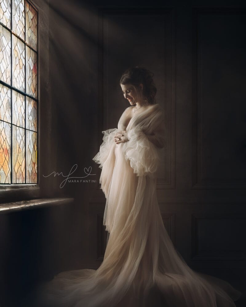Ritratto gravidanza fine art in stile Caravaggio Ritratto fine art maternità a Roma in stile pittorico rinascimentale, donna con abito in tulle verde e sfondo ocra, fotografia d'autore di Mara Fantini.
