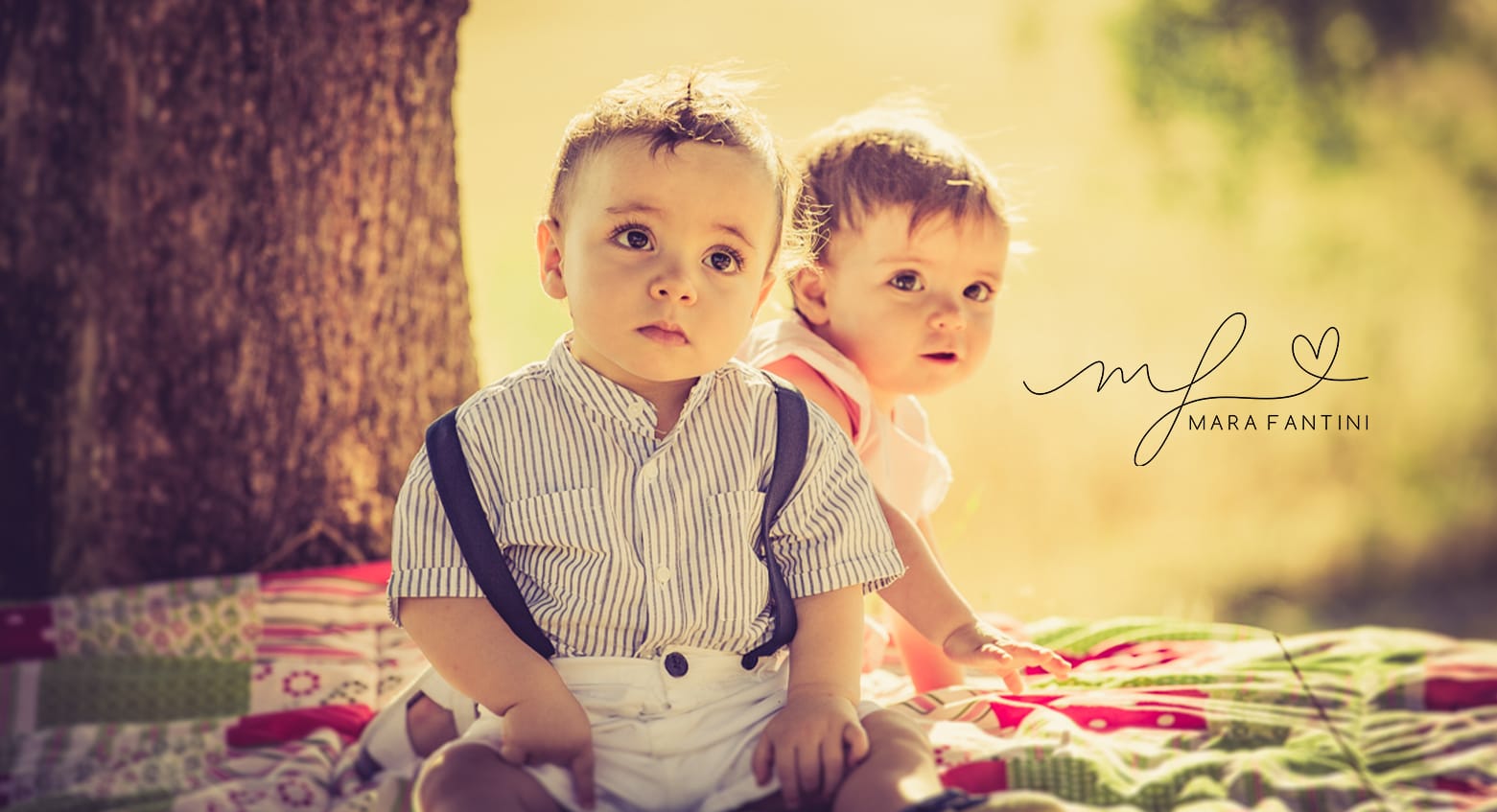 Bambini seduti su un plaid durante un servizio fotografico di famiglia al Parco degli Acquedotti a Roma, luce calda al tramonto