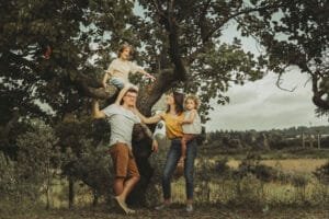 Papà con la bambina sulle spalle su un albero, famiglia riunita al Parco degli Acquedotti, Roma
